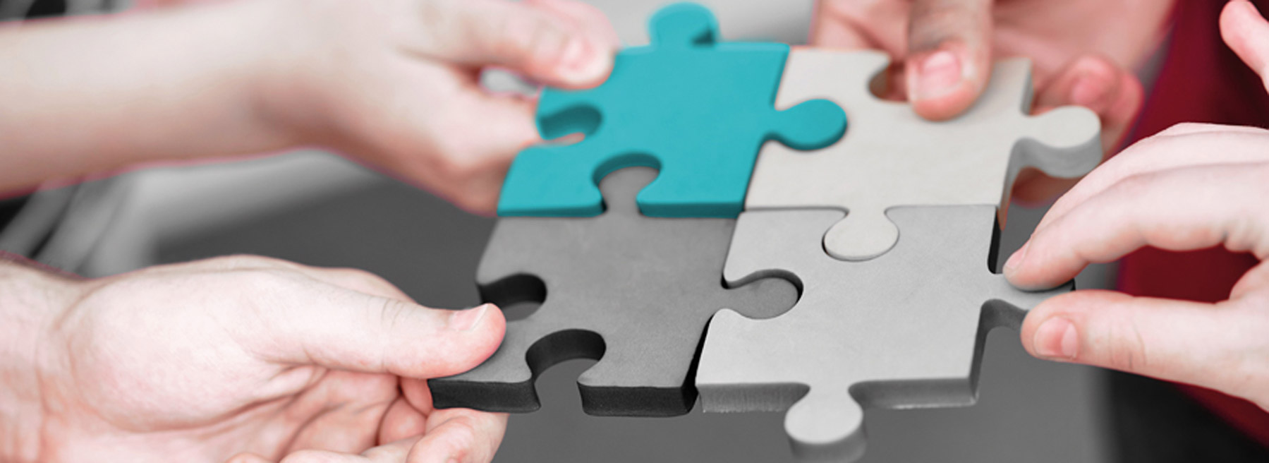 Kontakt Eine Gruppe von Menschen hält gemeinsam ein Puzzlestück - Teamarbeit und Zusammenhalt in Aktion!