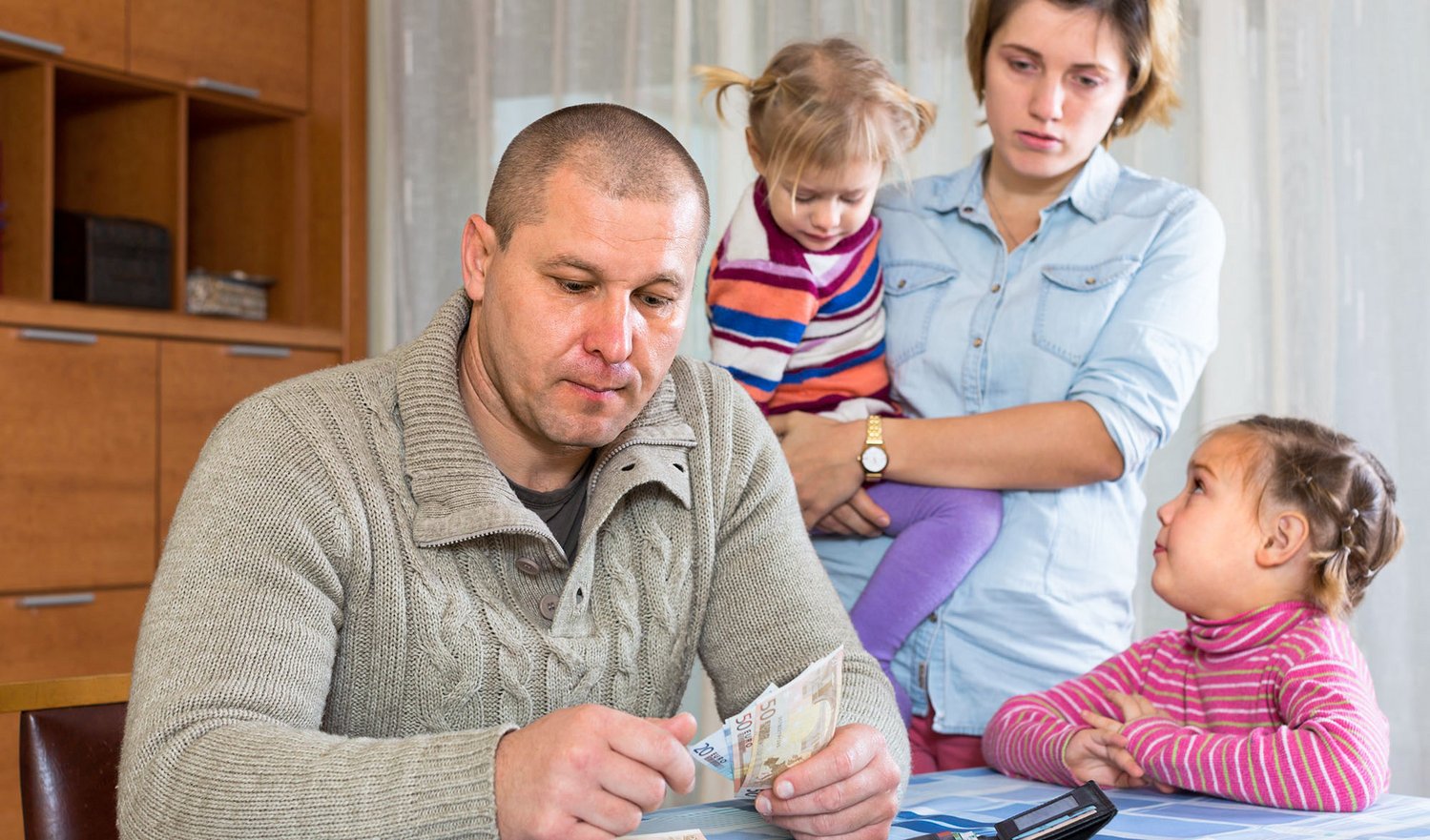 Das Foto zeigt eine Familie die ihr verbleibendes Geld zählt.