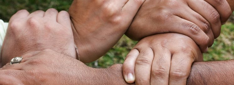 Mitarbeiten: Soziale Arbeit, Soziale Jobs, Praktikum Soziale Arbeit Hände von Menschen, die sich in einem Kreis halten. Eine starke Gemeinschaft, die zusammensteht und sich gegenseitig unterstützt.